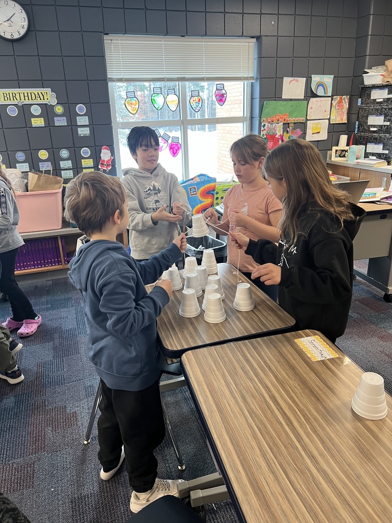 two males and 2 females using only a string and working togeth to build a christmas tree out of cups