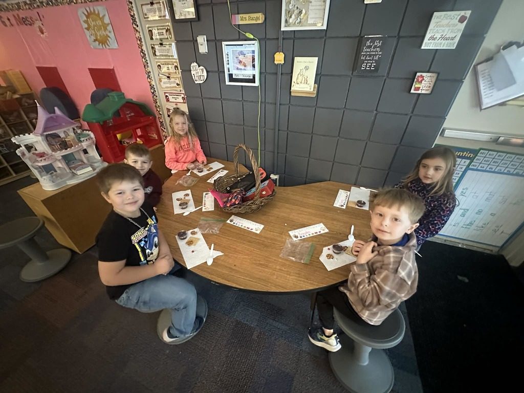 5 kindergartners sitting at a table making treats