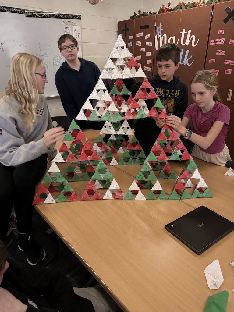 4, 7th grade students building a large christmas tree out of Serpinksi triangles