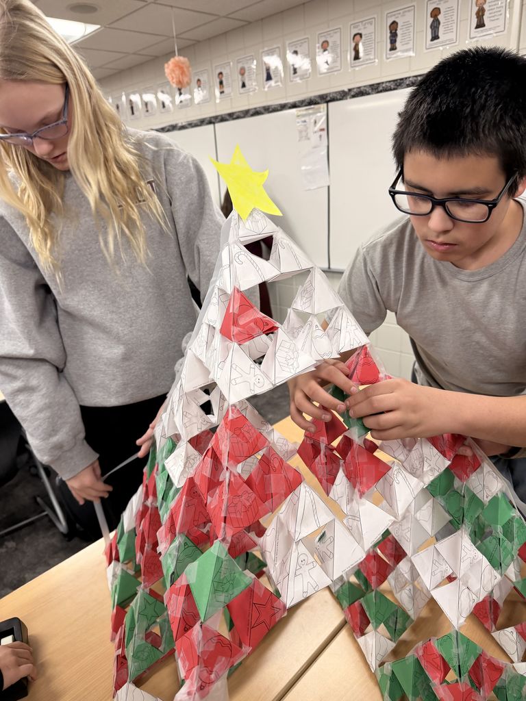 a female and male student creating a christmas tree out of many Serpinski triangles
