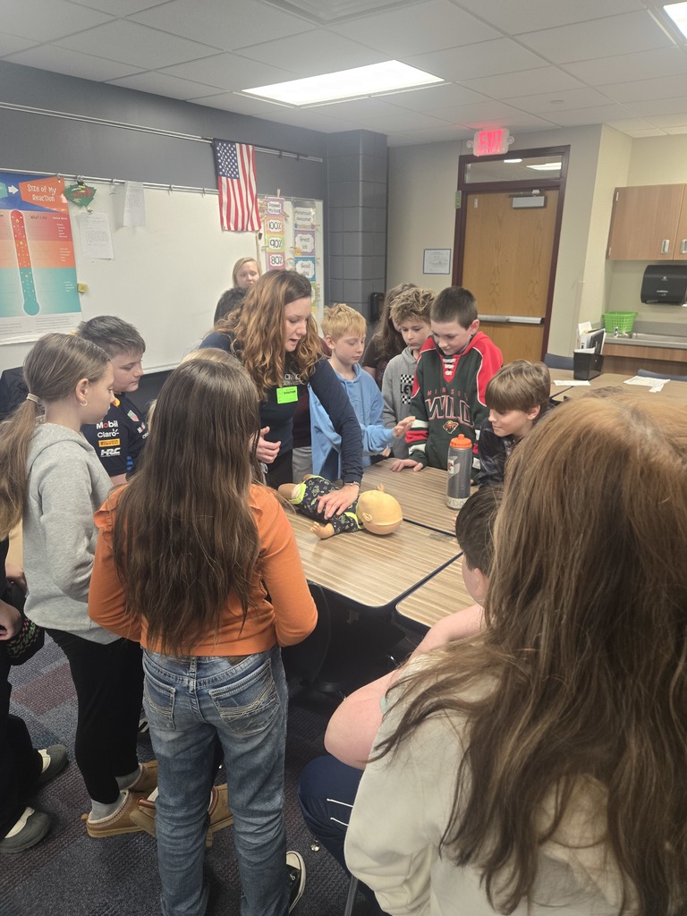 5th graders standing around a CRMC staff member doing CPR on a baby