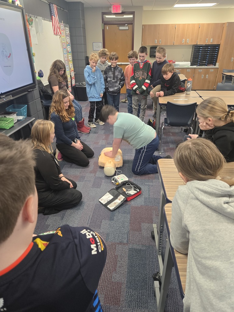 5th graders watching one of their peers practice CPR on Annie