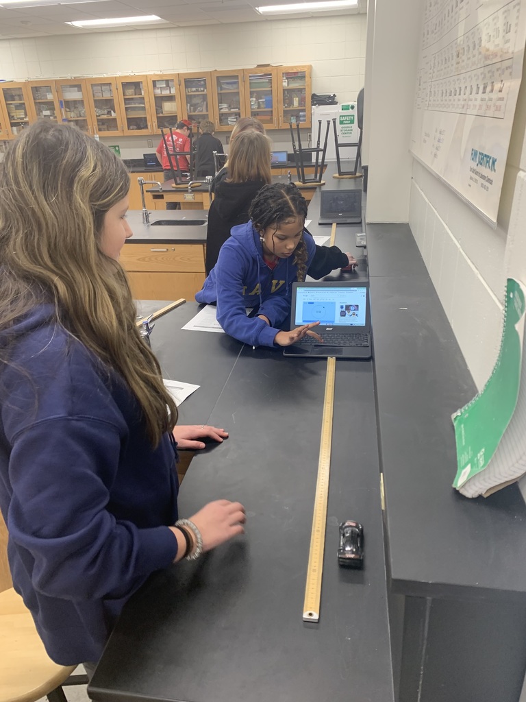 two student measuring the speed of a wind up car, one on the car and ruler the other on the computer