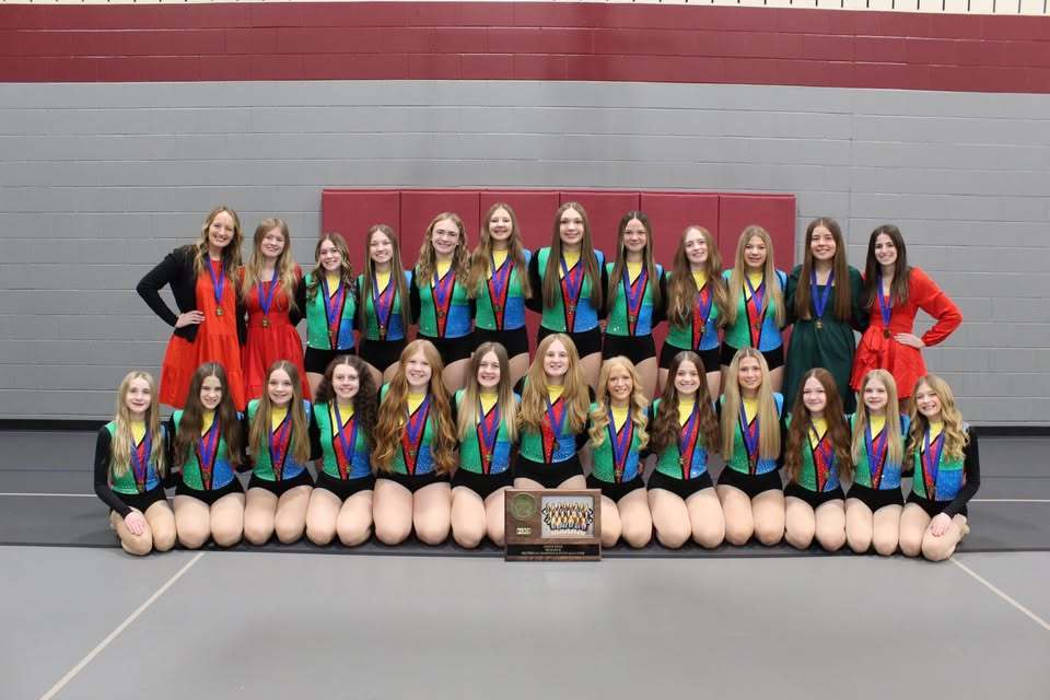 CI dance team posing for photo in their red, green, blue and yellow uniforms