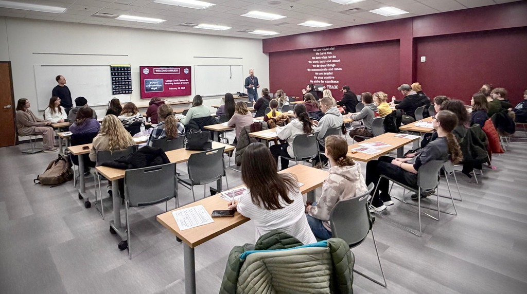 10-11th graders and their parents listening to college credit options