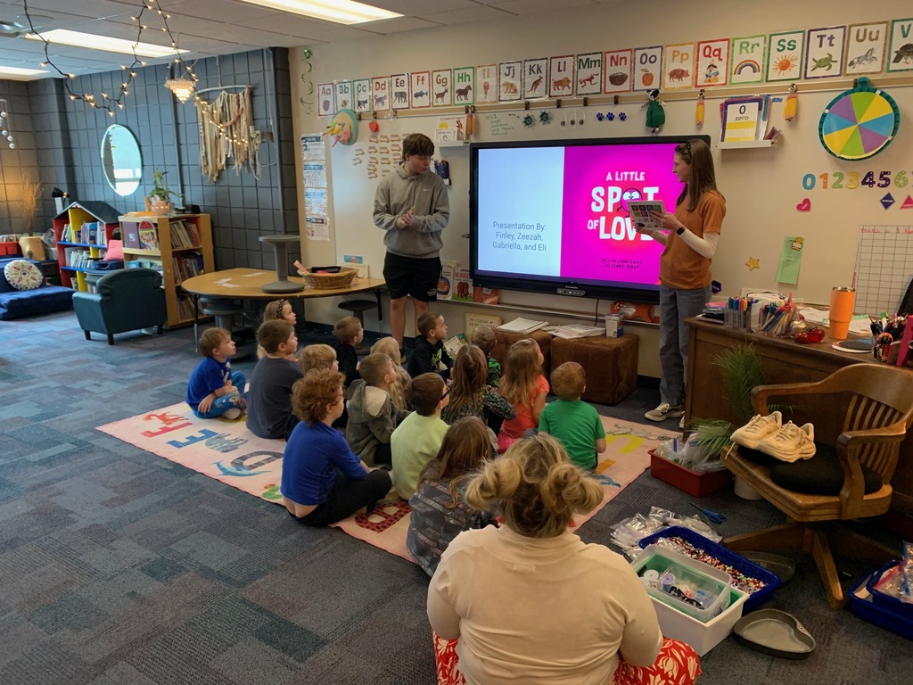 a male and female HS student standing in front of a kindergarten classroom giving a lesson about big emotions