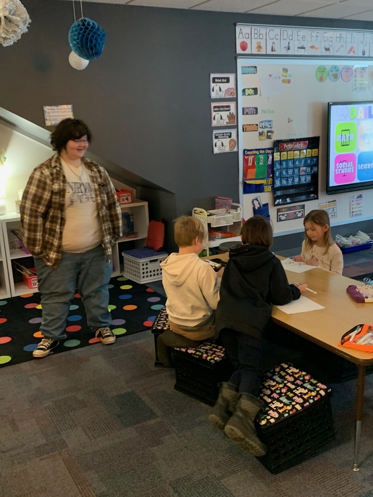 a hs student standing next to a table of CRES students