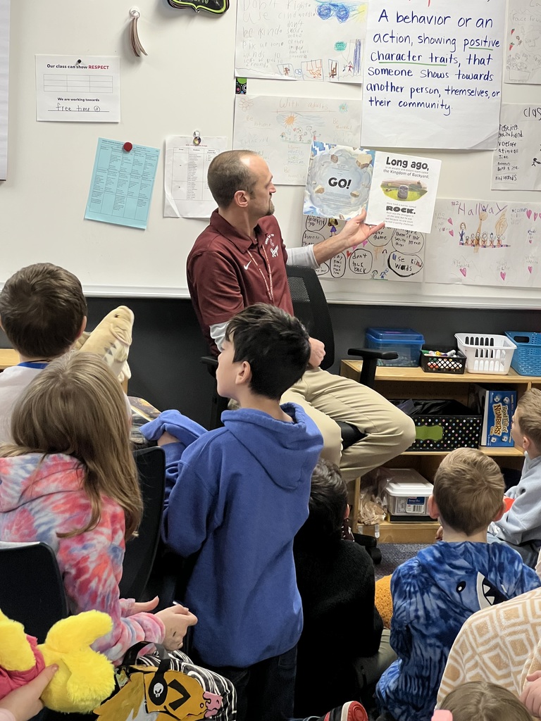 Superintendent Aulie reading Rock, Paper, Scissors to 3rd grade