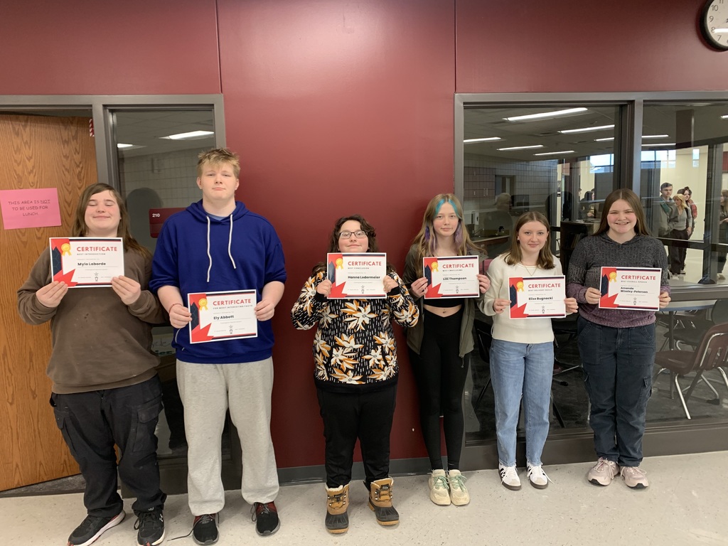 6 9th grade students holding certificates they received in English class for their speeches