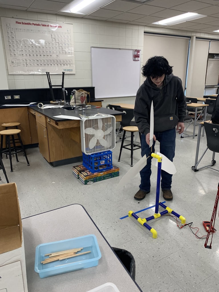 male student put the last piece of his wind turbine together