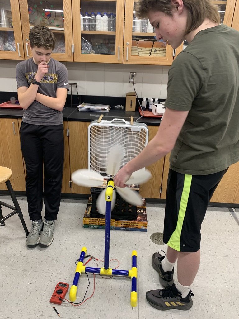 two male 9th grade students using fans in earth science