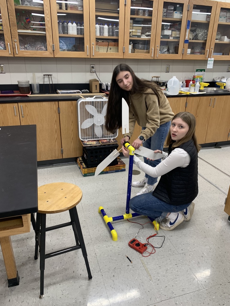 two female students working to put together their wind turbine
