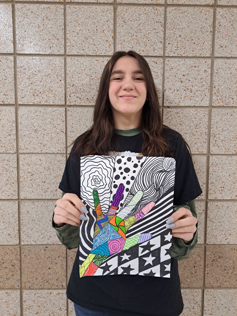 Female student holding hand art with multiple colors and patterns