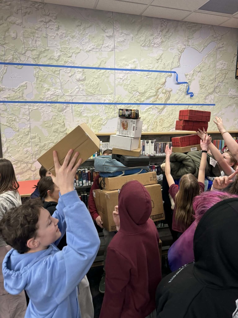 7th graders stacking boxes, fake bricks and camping equipment at Shanaboom
