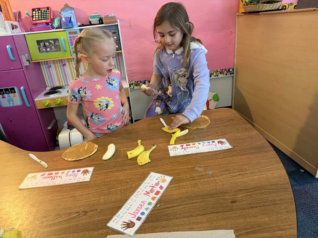 two girls getting ready to cut up a banana