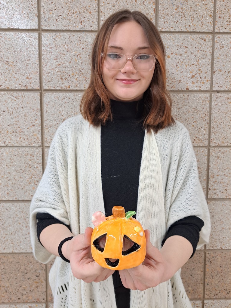Female student holding a jackolatern tealight that was made in 3d art class