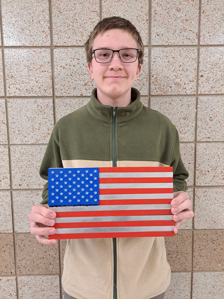 Male student holding an painting of the American flag