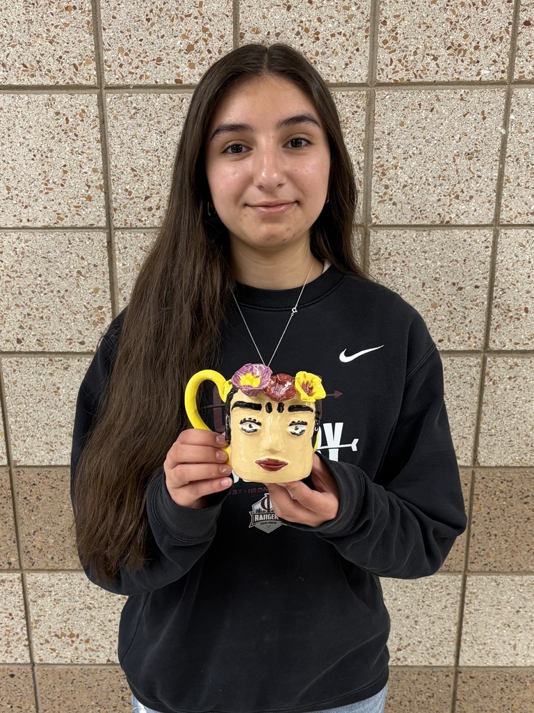 female artist of the week holding a face mug with flowers around the top