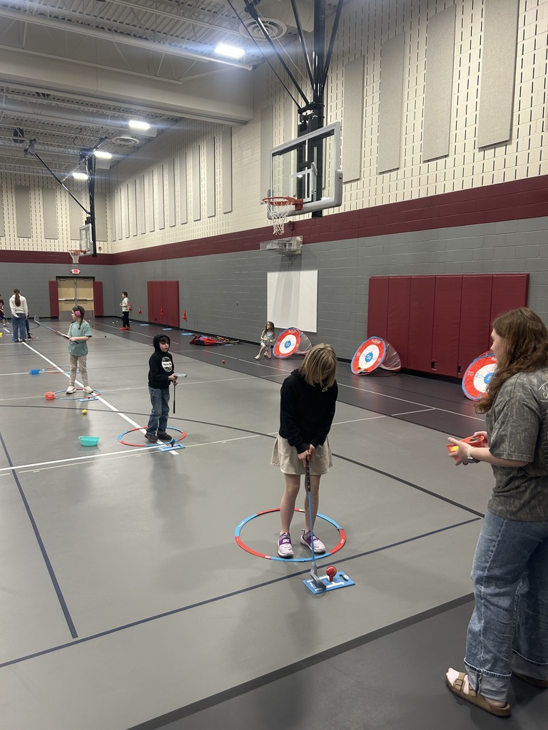 students standing in a circle learning how to play golf