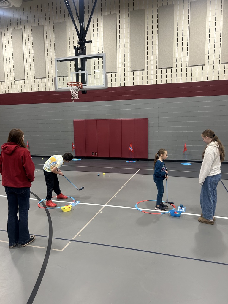 two more students with older high school students helping them learn golf
