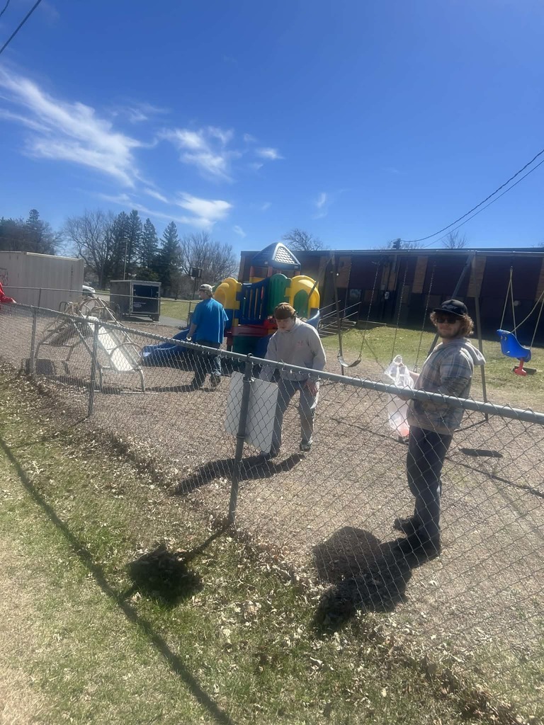 male students in the church playground picking up garbage