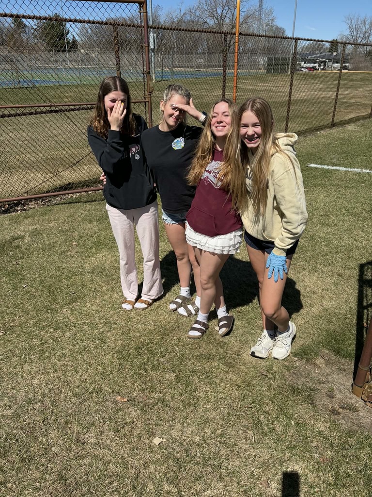 4 female students walking to pick up trash