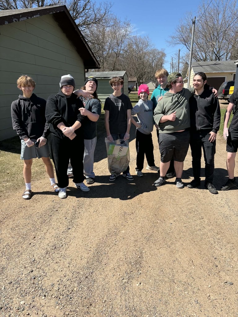 group of males standing in the alley posing with the trash they have picked up