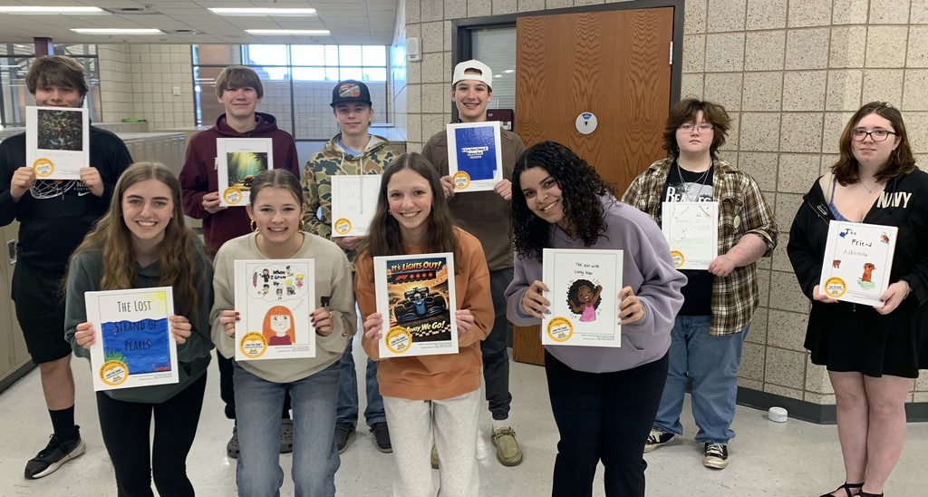 students in children's lit class holding their published books