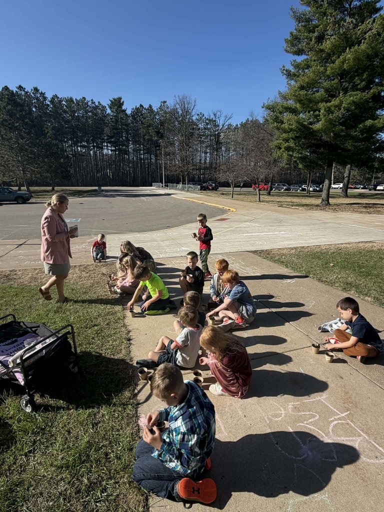 kindergartners sitting on the sidewalk planting veggies and fruits from dietician Miranda from CRMC