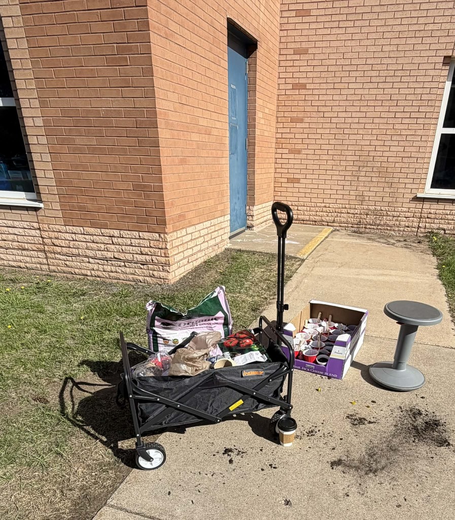 a wagon filled with dirt, seeds, and solo cups ready to be planted