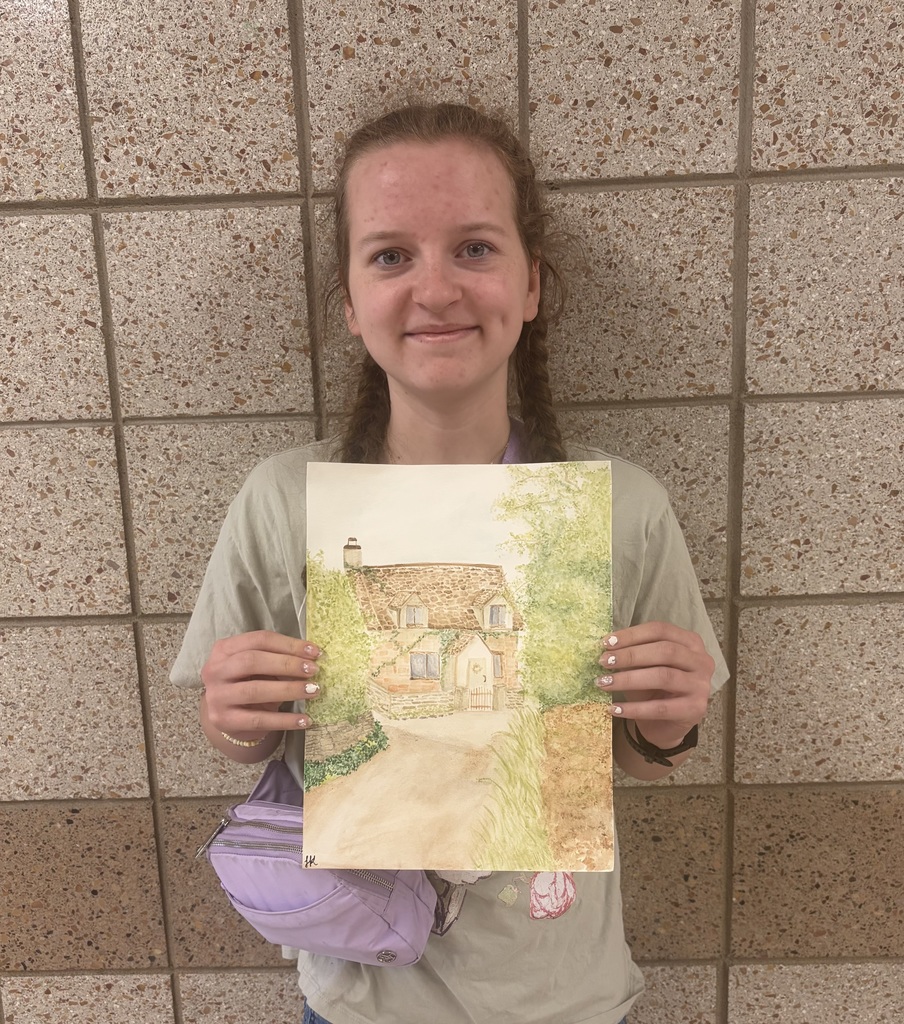 female 9th grader holding a drawing and colorin gof a quaint cottage with greenery and trees lining the sideawalk