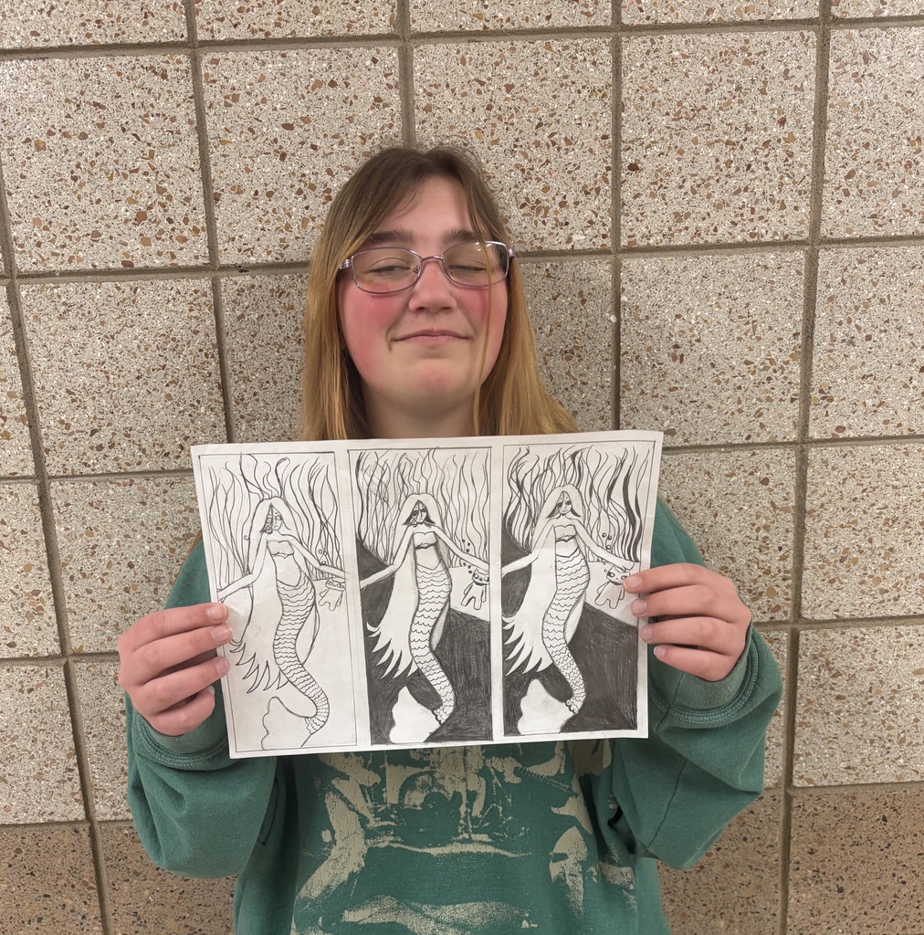 female student holding a drawing of a mermaid