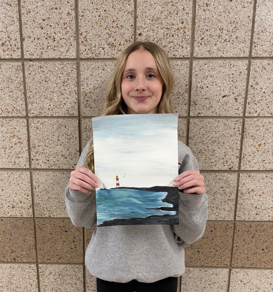 8th grader holding her watercolor painting of a lighthouse on a point and water and shore