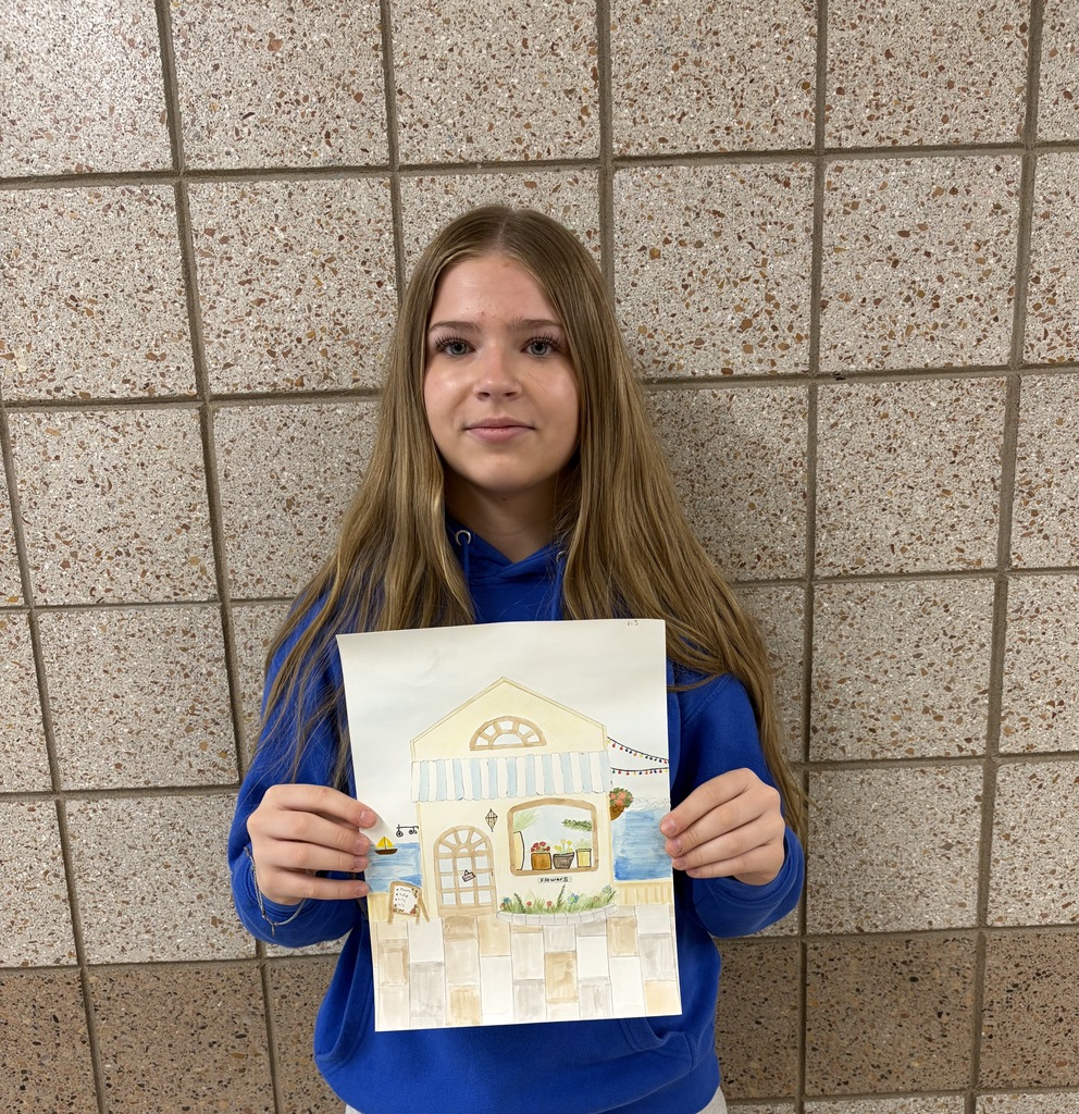 Female 8th grader holding a drawing of a house on the water