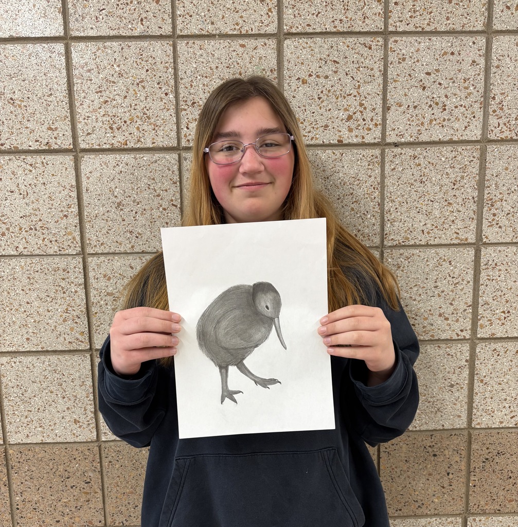 Female 9th grader holding a drawing of a black bird 
