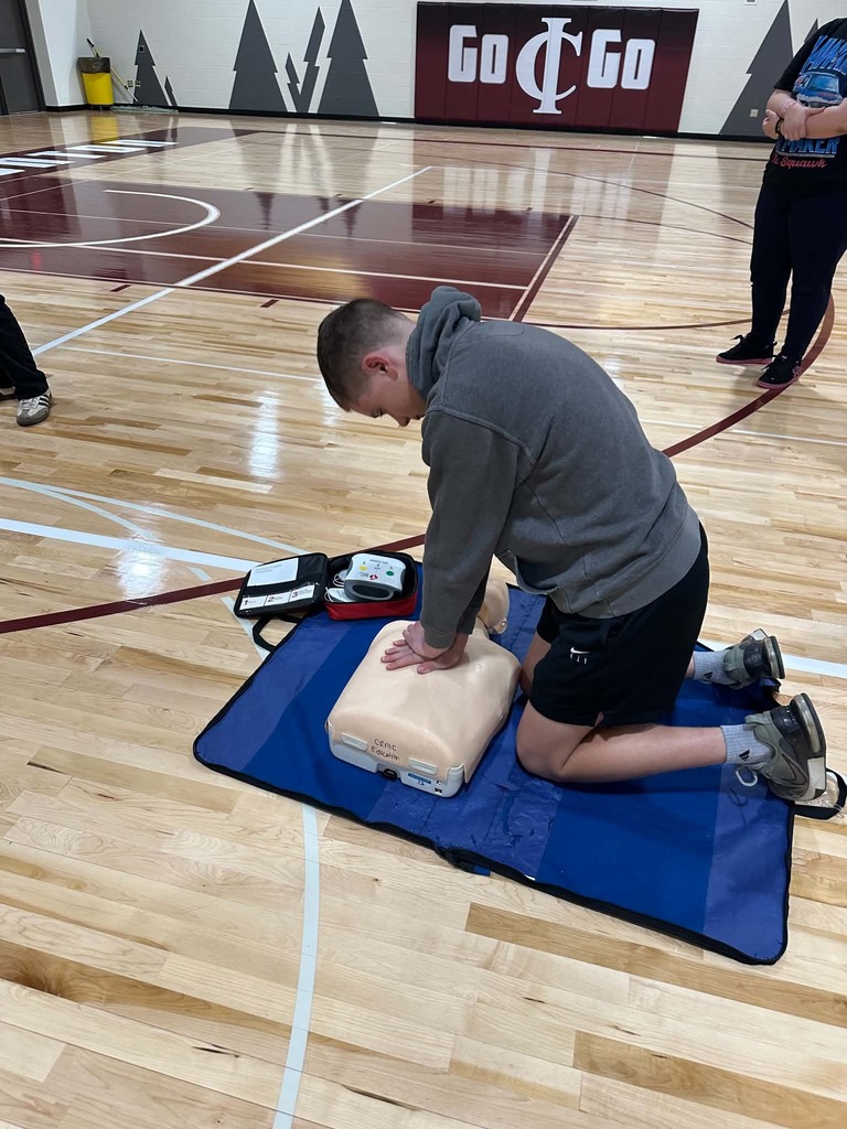 male student performing CPR on a dummy