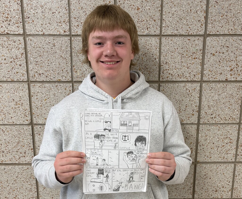 ale student holding a comic paper that he created