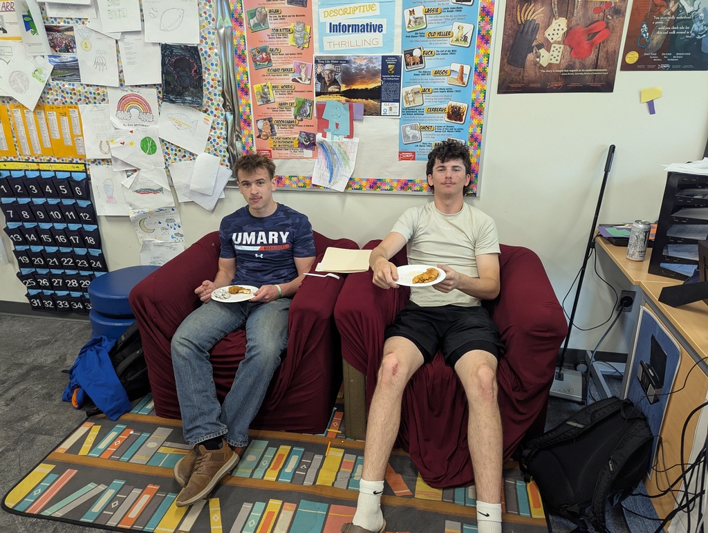 creative writing students sitting in chairs eating their potluck food