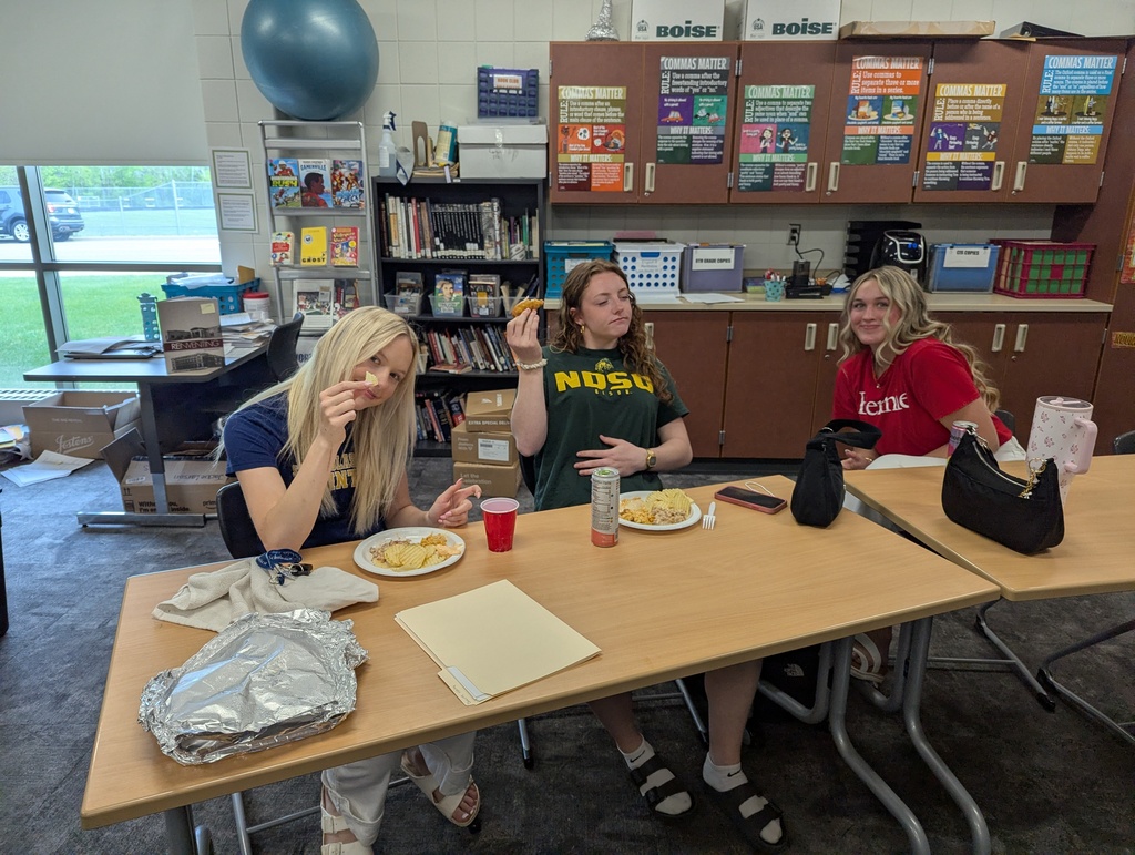 three female senior sitting at tables eating their potluck food on their last day