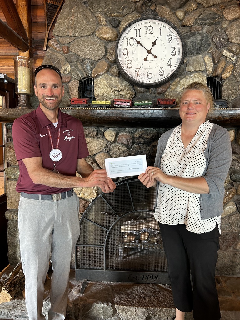 Rick Aulie and Heidi from Ruttger's holding a check being donated to CRES