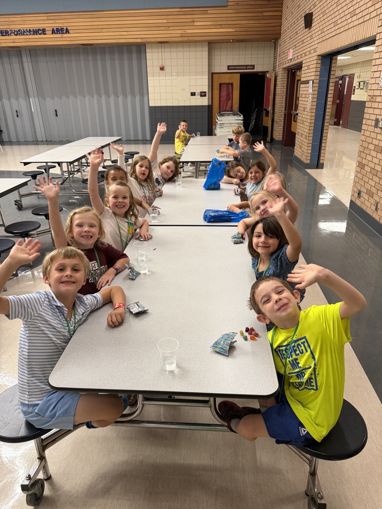 kindergarten student sitting at a cafeteria table 