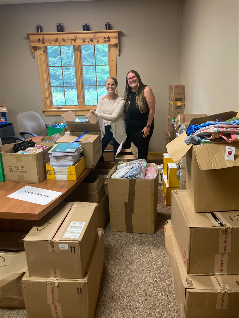 Two staff with boxes full of school supplies