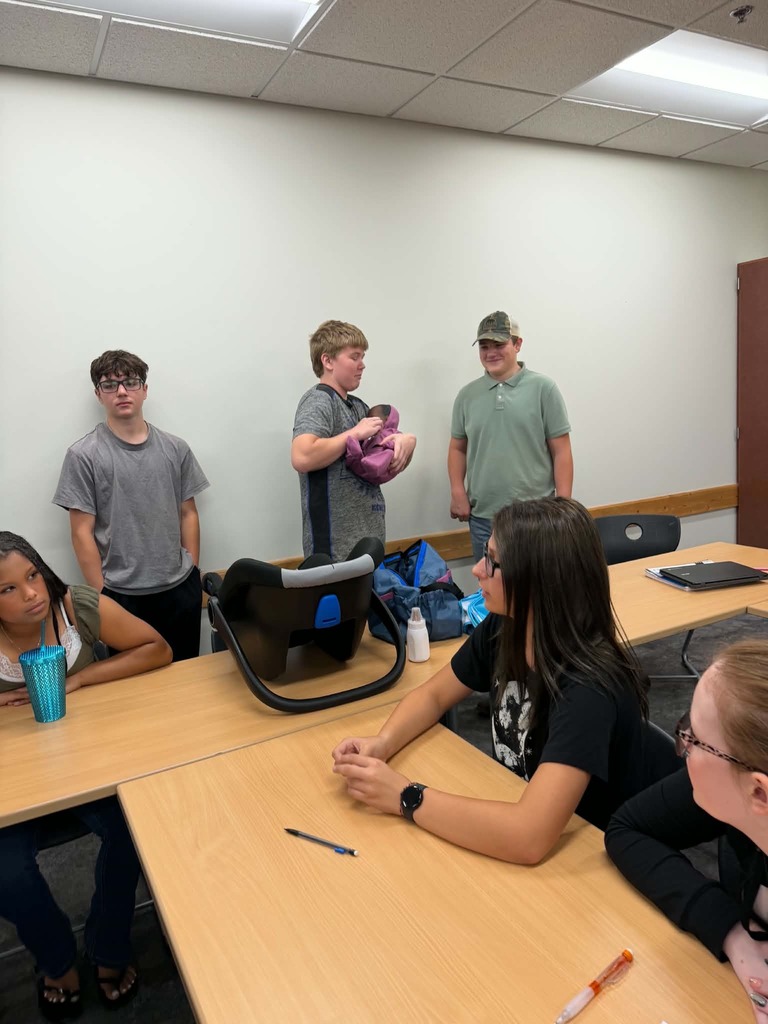 three male students and three females, one of the males is holding a baby