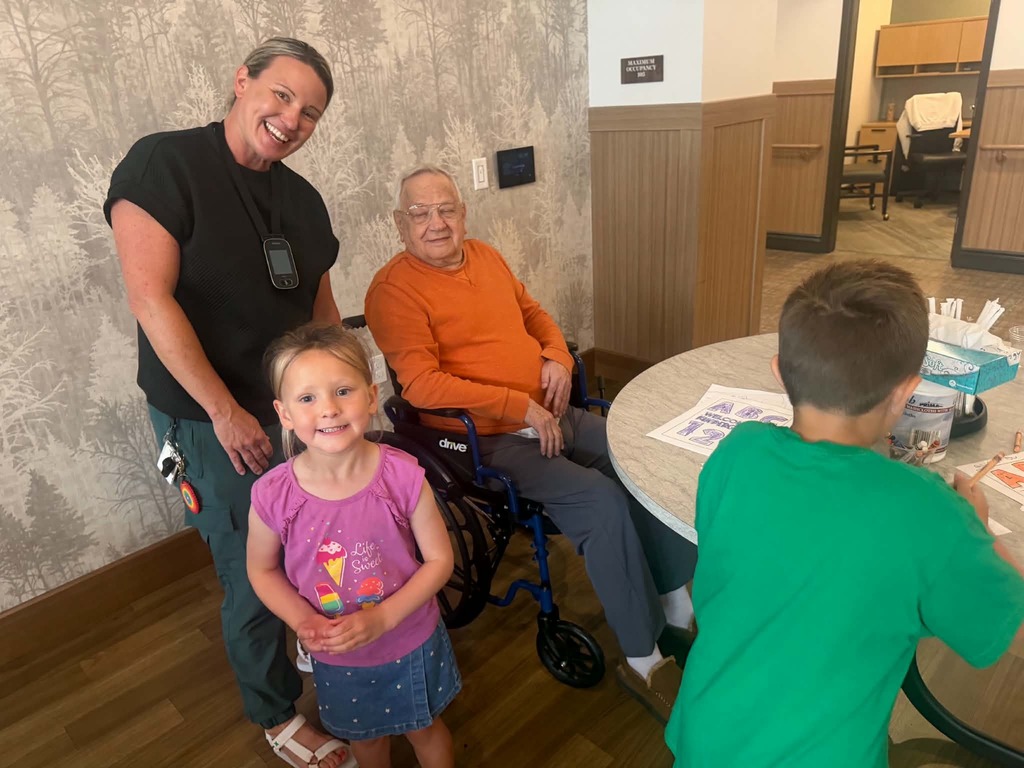 Teacher Ms. Cash and a kindergarten student with a resident at Heartwood
