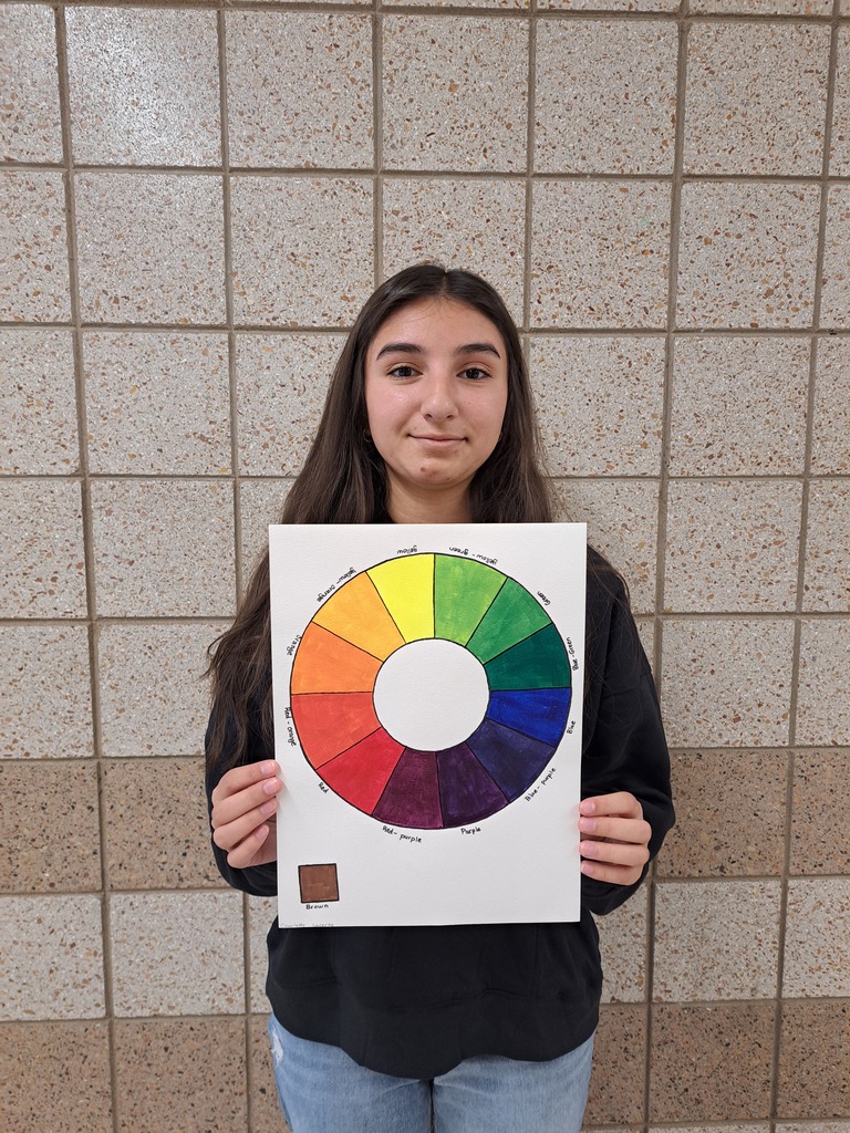 female student holding her painting of the color wheel