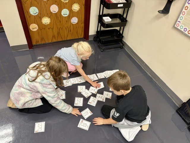 two females and one male sorting numbers