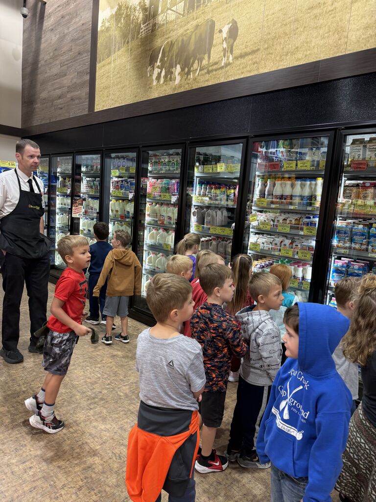 Super One manager with kindergartners in the dairy isle at SUper One