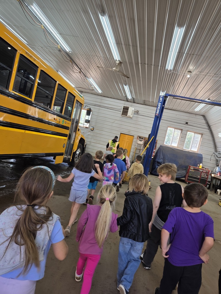 kindergartners walking through the bus garage
