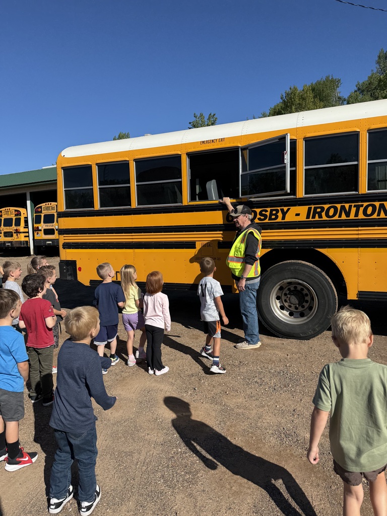 bus driver showing kindergartners the exit window