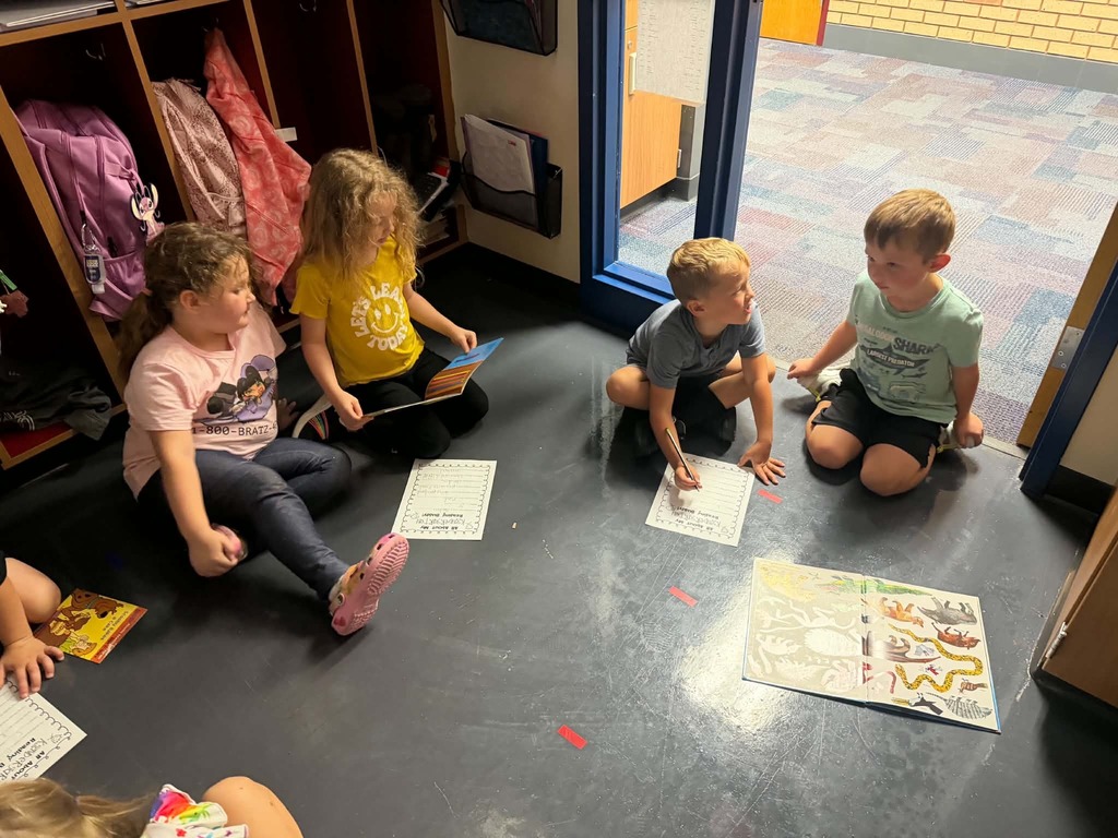 2nd graders and kindergartners reading together in the locker bay